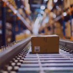 Cardboard box on conveyor belt in warehouse supply chain facility, illustrating global trade logistics and distribution processes.